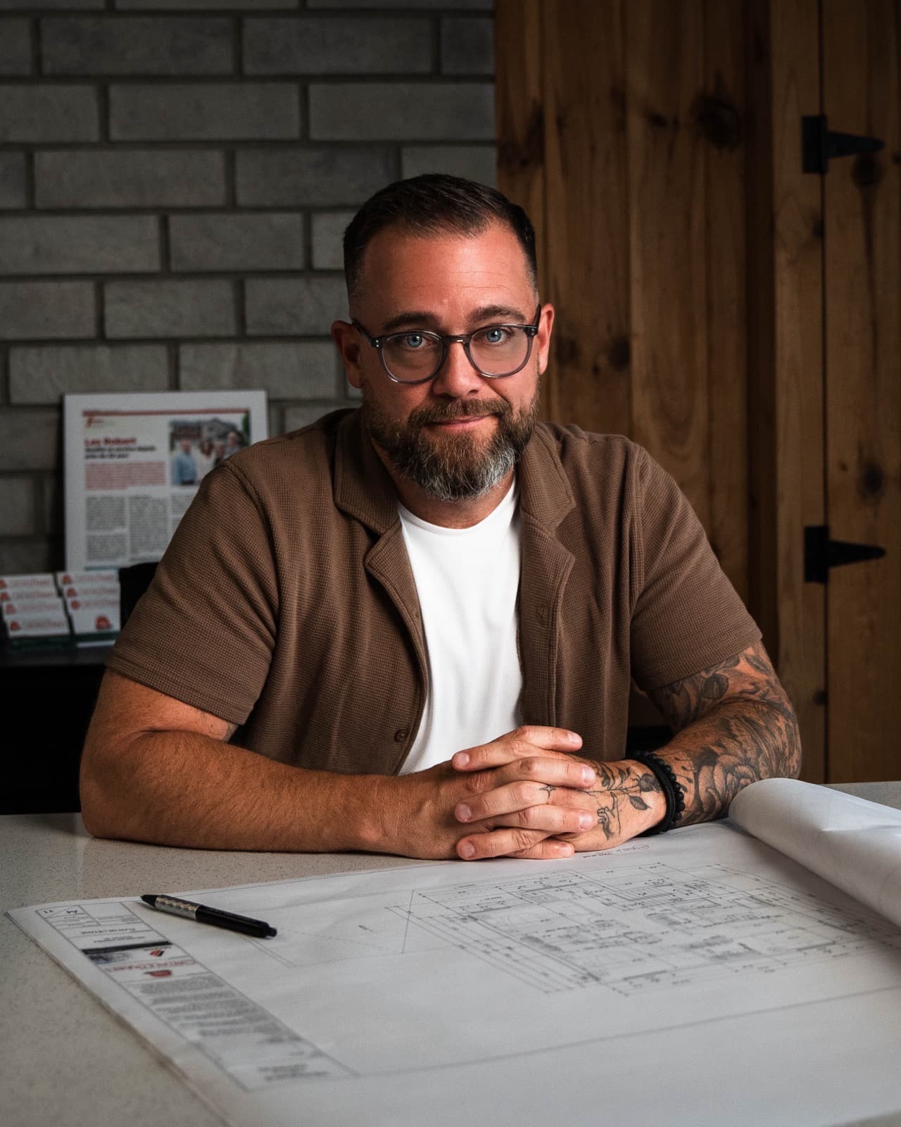 Patrick, de La Planche à Dessin, devant des plans de maison
