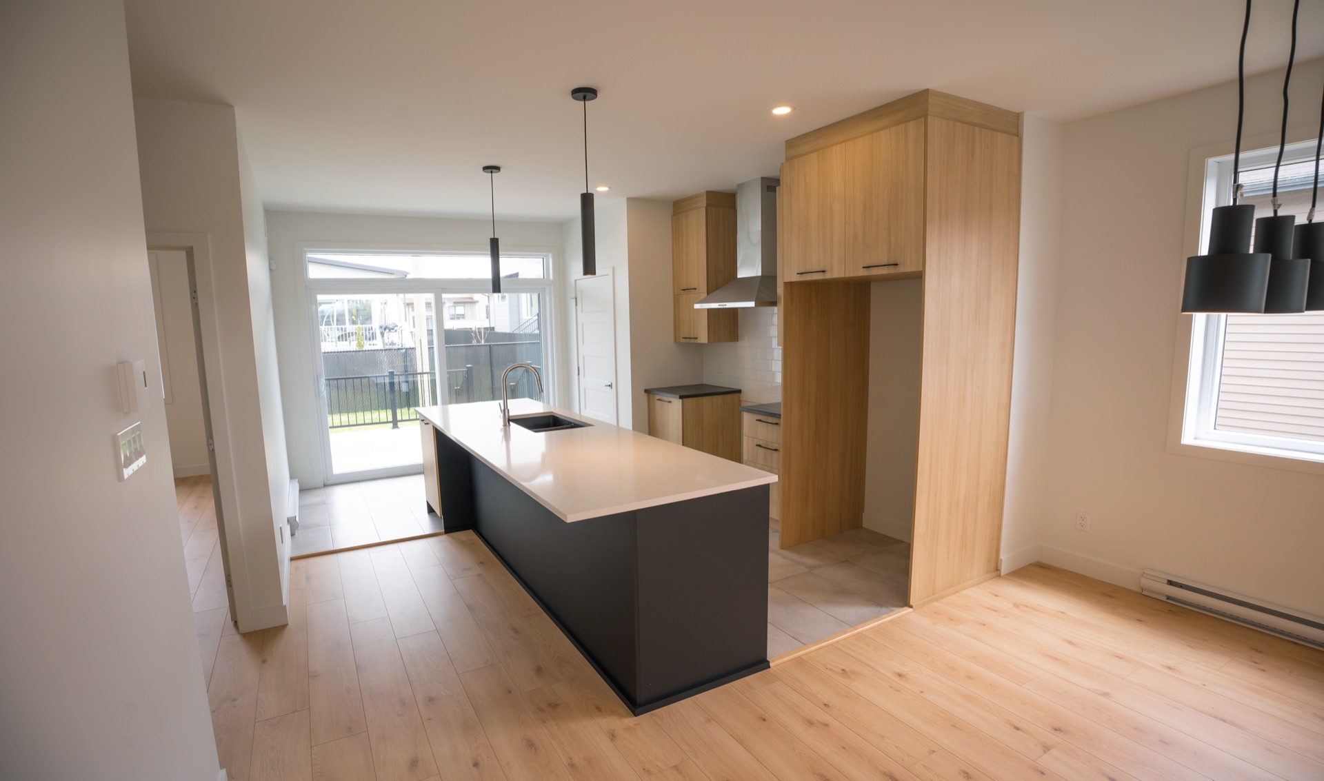 Cuisine avec îlot central en quartz et porte-patio sur la cour